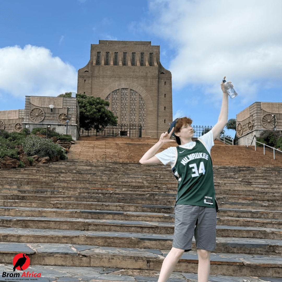 Student posing playfully on the steps of the Voortrekker Monument in Pretoria, South Africa